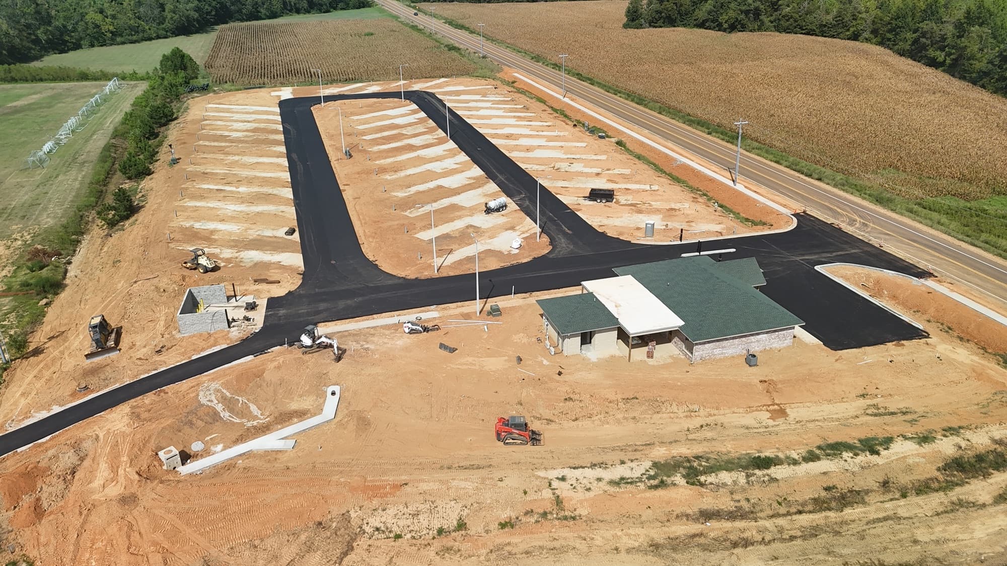 Wide aerial view of Evergreens RV Park's full loop of sites along the highway